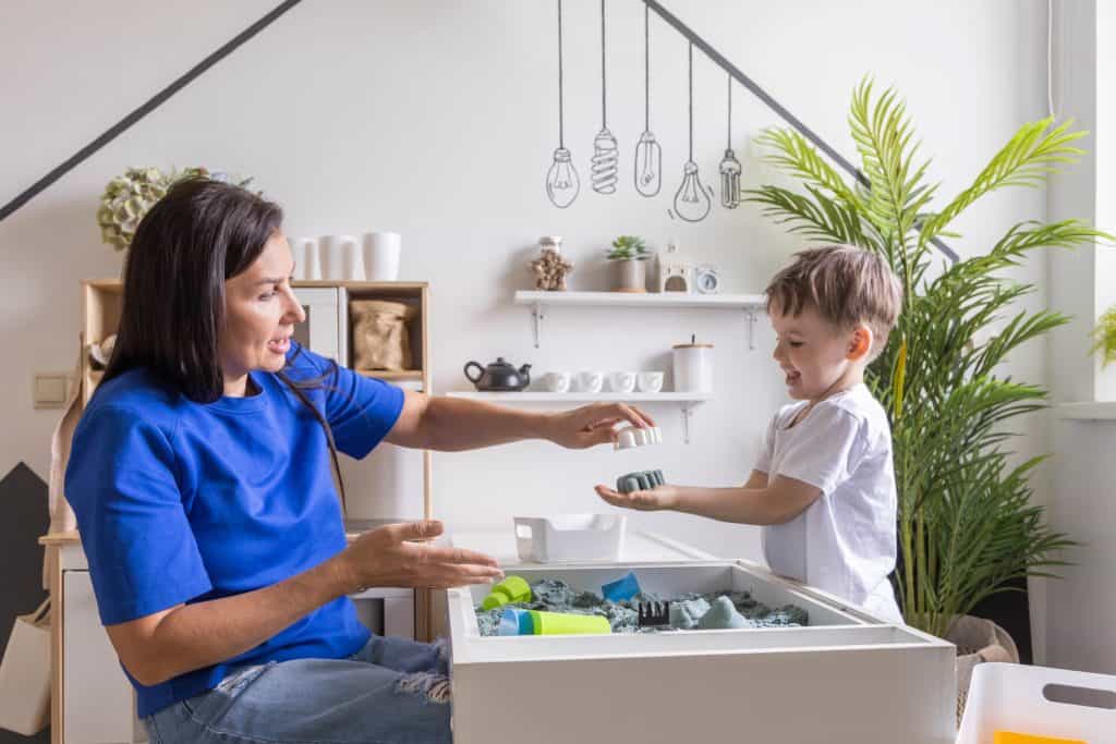 mom and little boy playing with kinetic sand