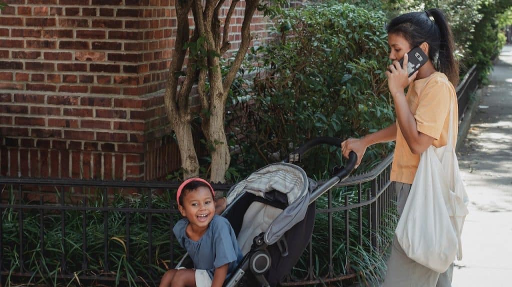 woman pushing a girl on a stroller