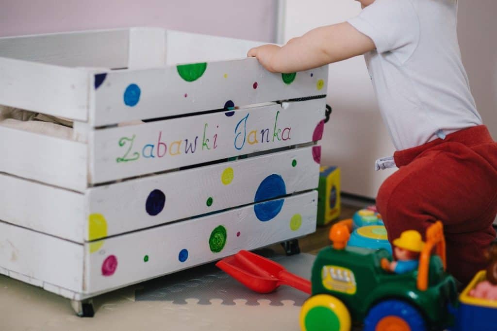 baby clinging into a crate