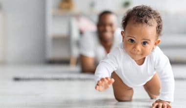 cute baby crawling in front of dad