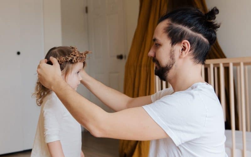 dad putting flower crown on daughter