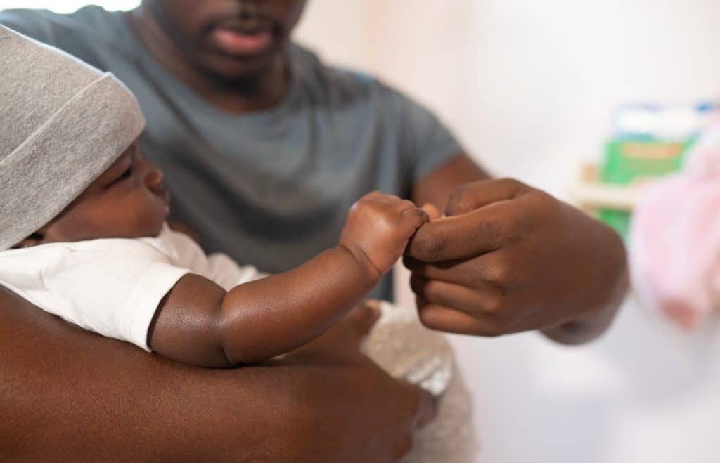 dad touching baby's hand