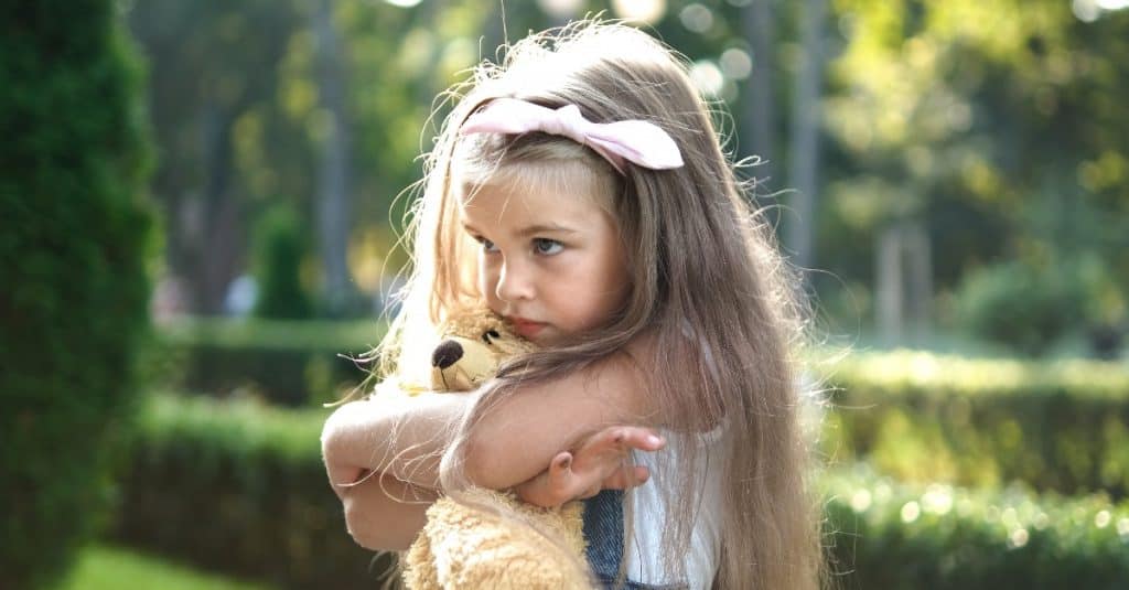 girl hugging her teddy bear