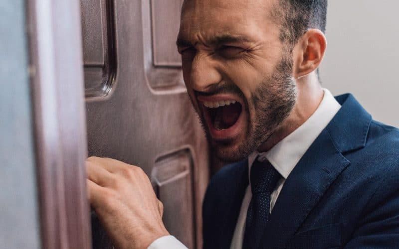 man shouting in front of a door