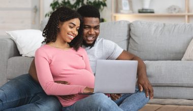 pregnant couple watching something from laptop