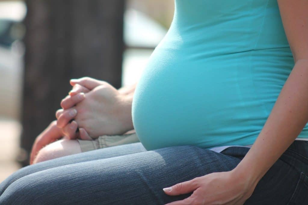 pregnant woman holding hands with husband