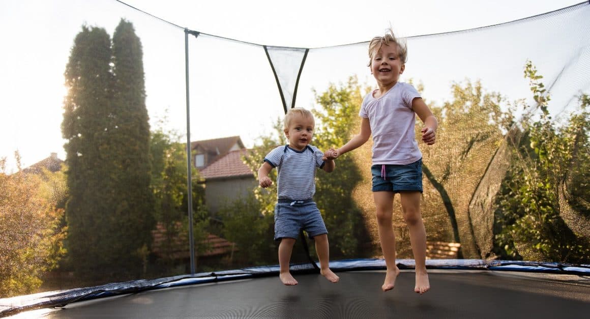 siblings jumping on a trampoline
