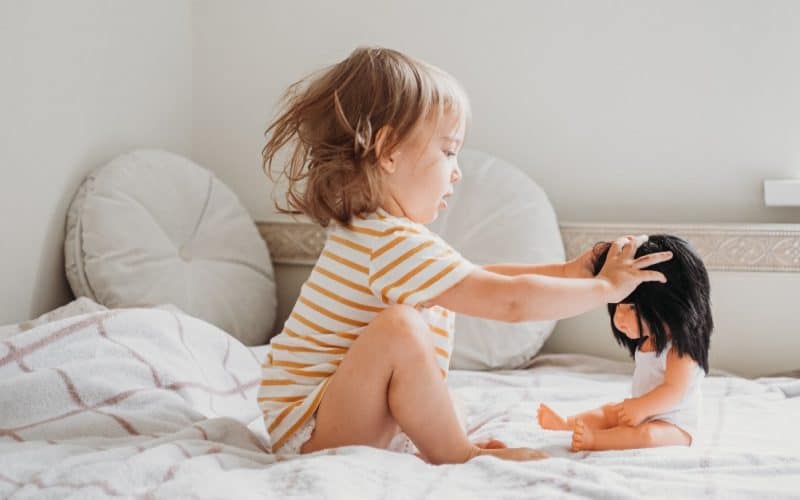 toddler playing with her doll