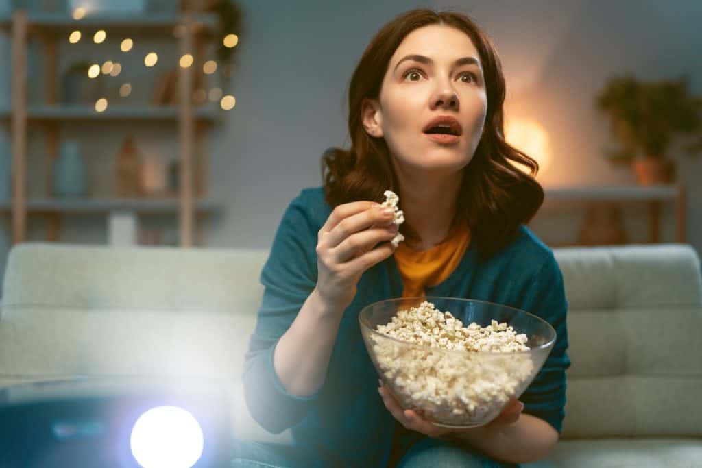 woman eating popcorn while watching a movie