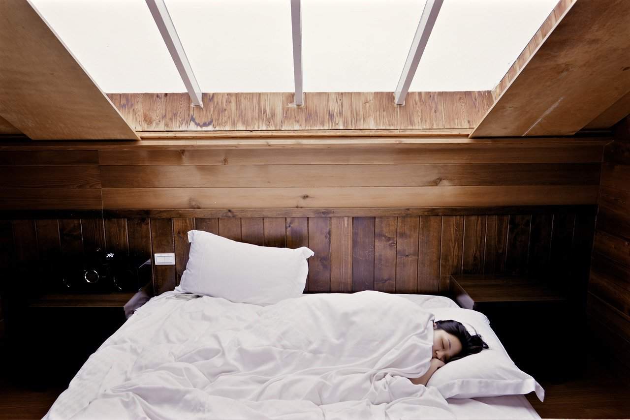 woman resting white sheets