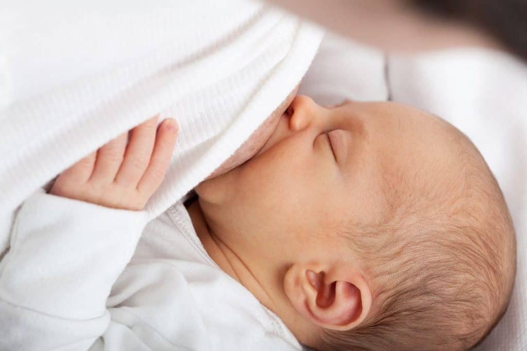 baby drinking milk from mom's breast