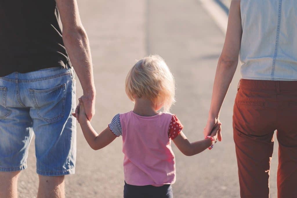 baby girl holding parents hands