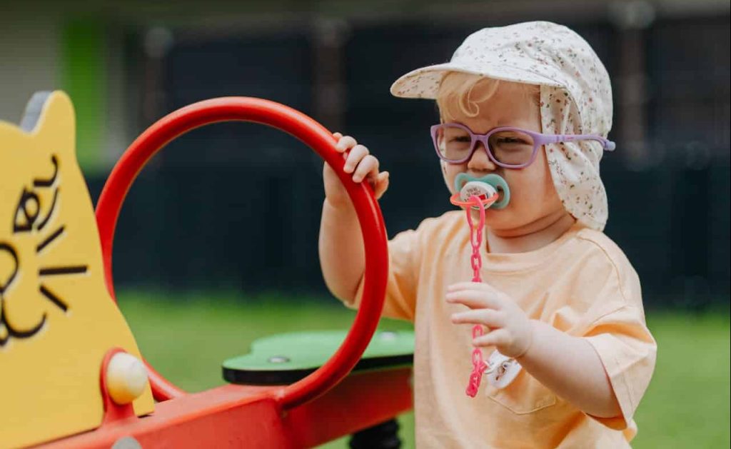 baby with a pacifier in a park