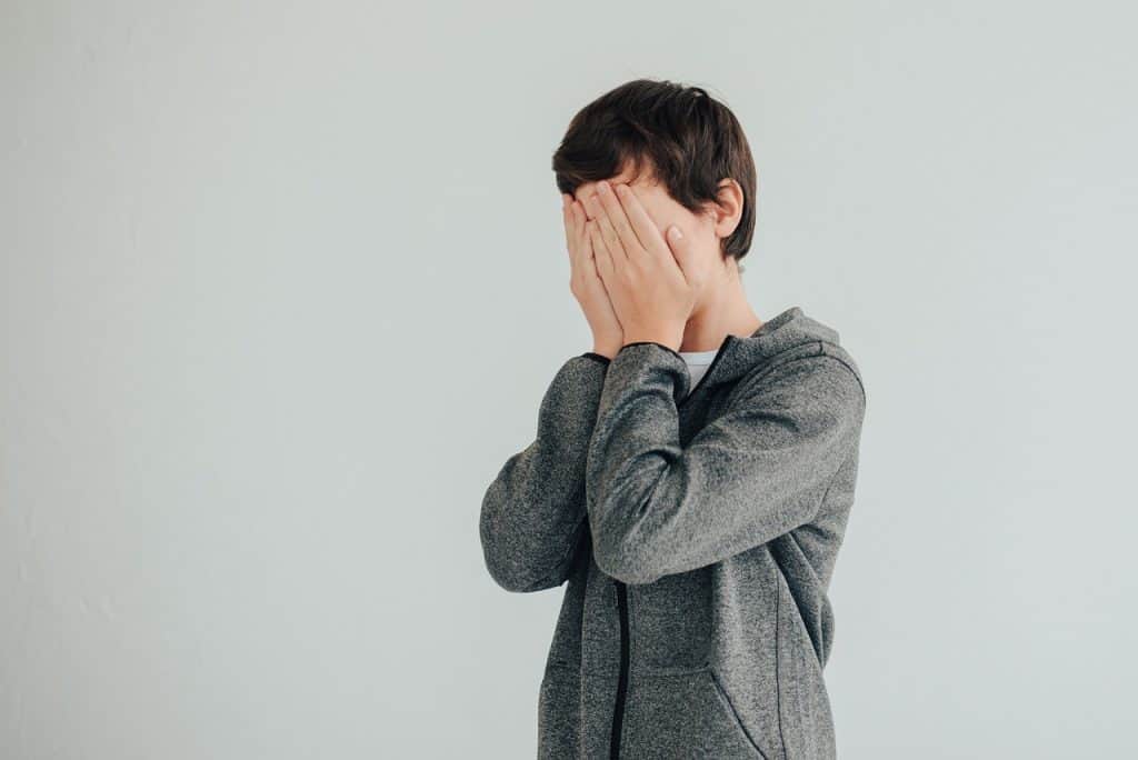 boy covering his face