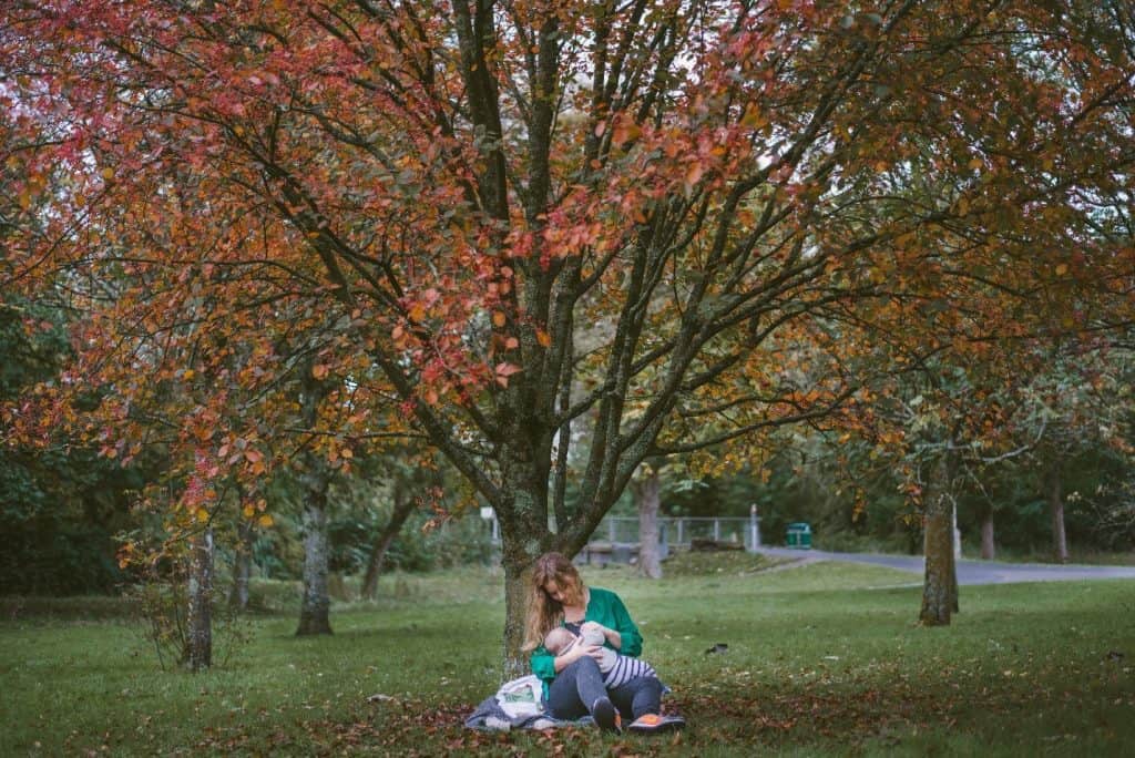 breastfeeding woman under a tree