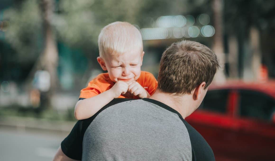 dad carrying crying baby boy