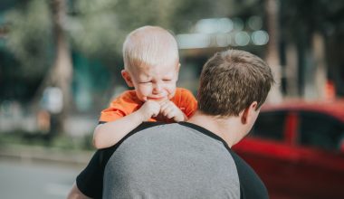 dad carrying crying baby boy