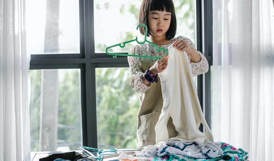 girl putting clothes on hanger