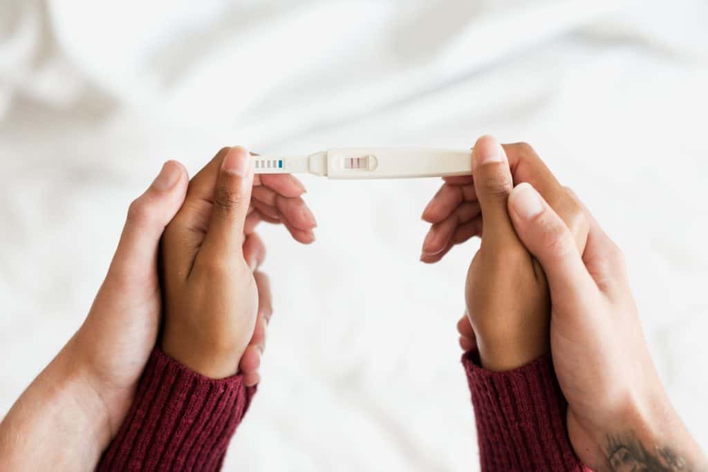 hands holding pregnancy test