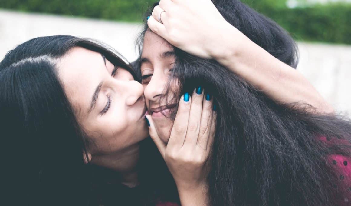 mom kissing her daughter