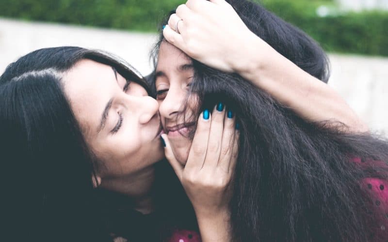 mom kissing her daughter