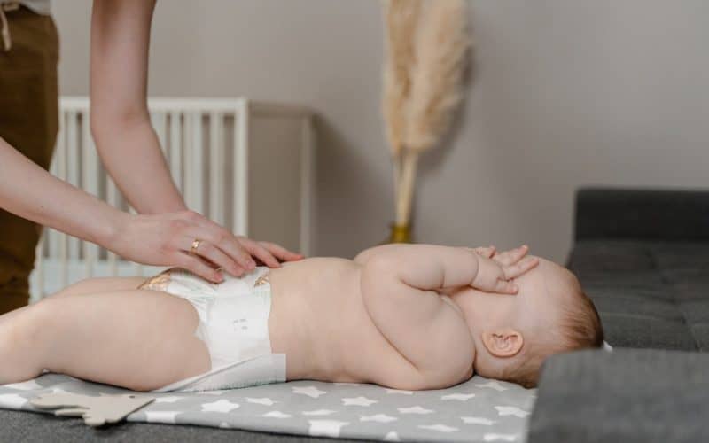 mother changing baby diaper