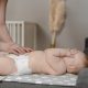 mother changing baby diaper