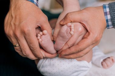 parents holding baby's feet
