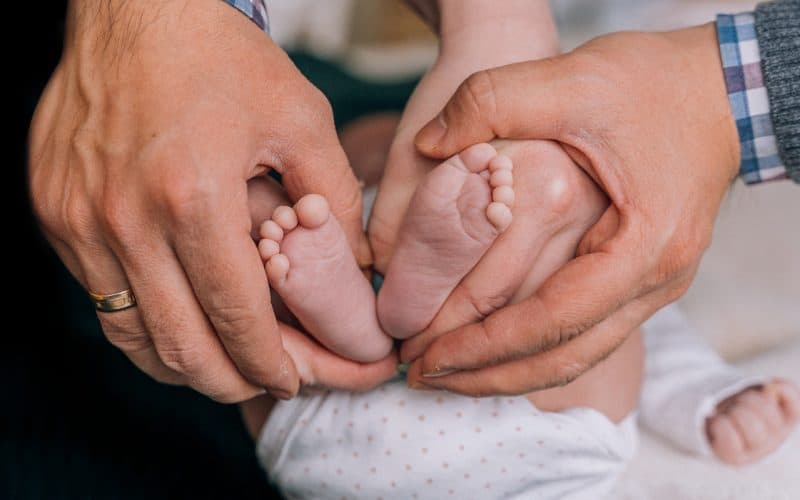 parents holding baby's feet