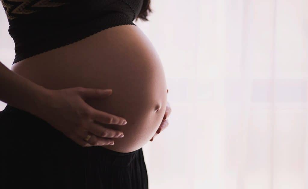 pregnant woman holding her tummy