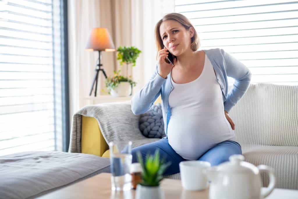 pregnant woman in pain making a phone call