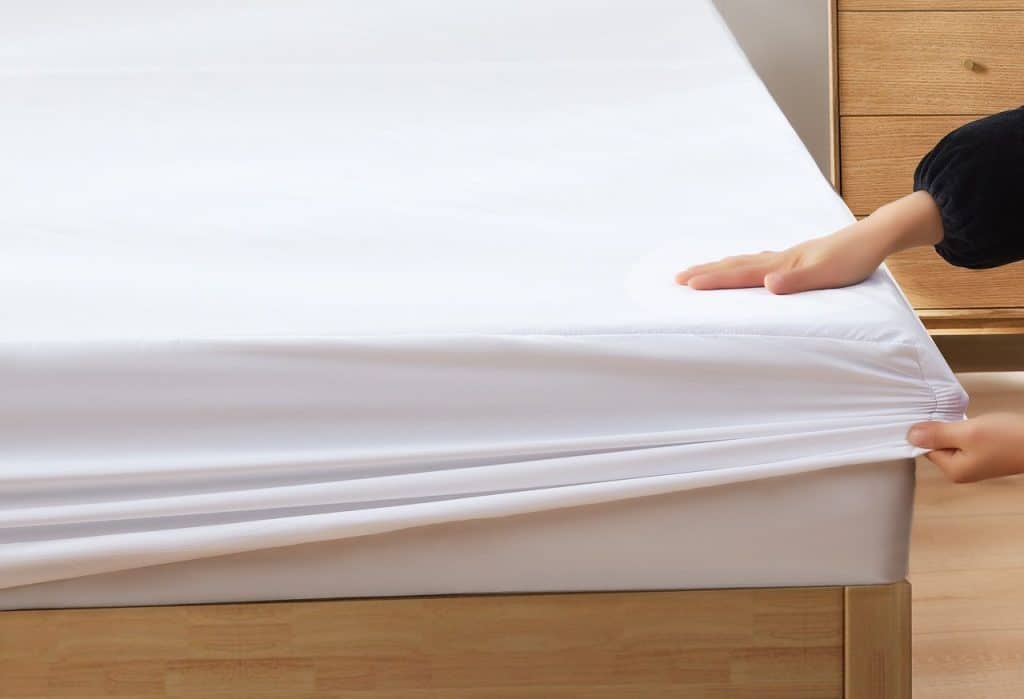 putting sheet on bed