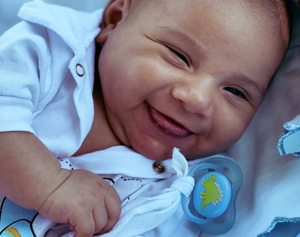 smiling baby with pacifier