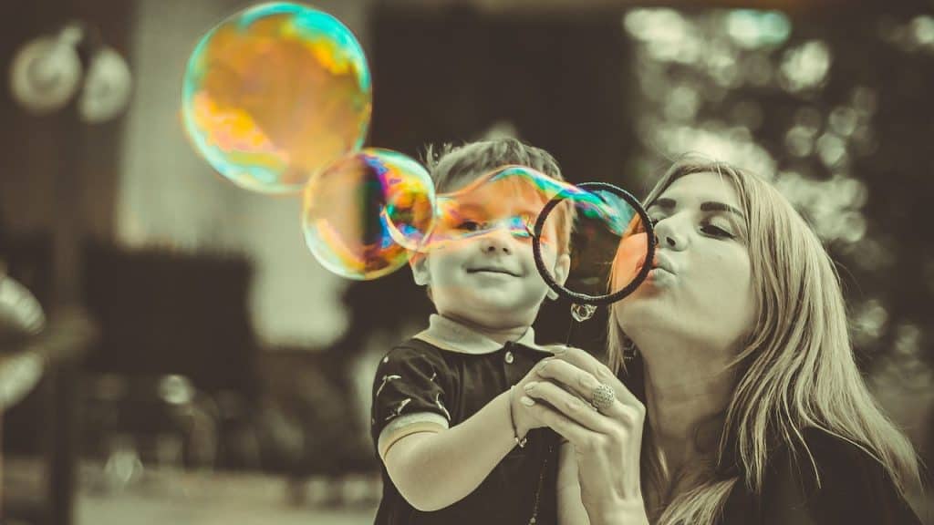 woman and child playing with bubbles