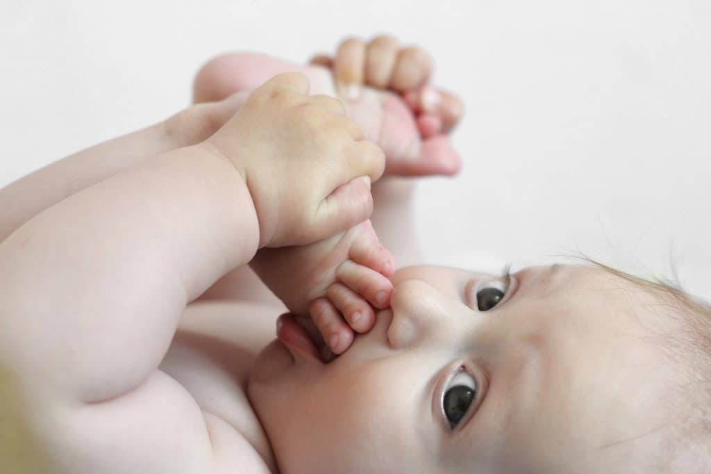 adorable baby boy sucking his feet