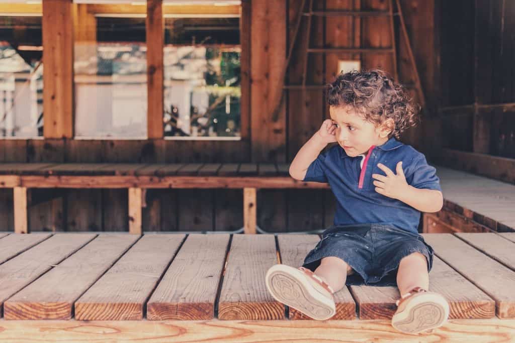 boy sitting on wood