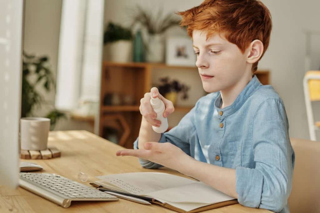 boy using hand sanitizer