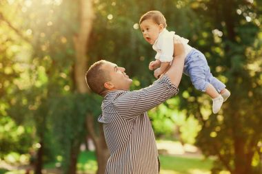 dad carrying baby up in the air