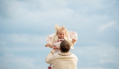 father carrying baby girl up in the air