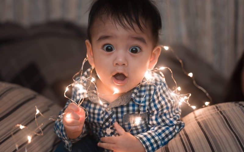little boy playing with chirstmas lights