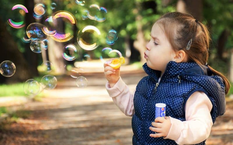 little girl blowing bubbles