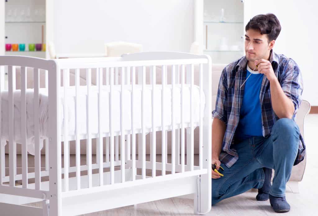 man measuring crib