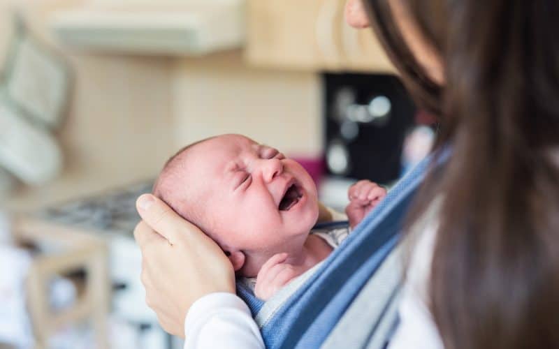 mom carrying crying baby