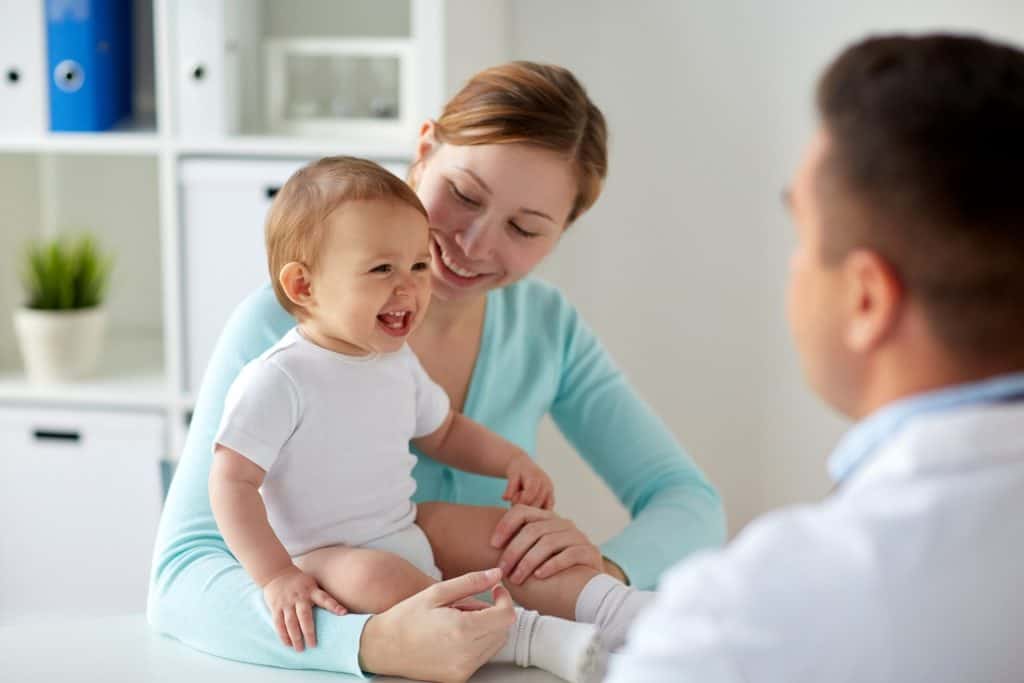 mom consulting a doctor while carrying a baby