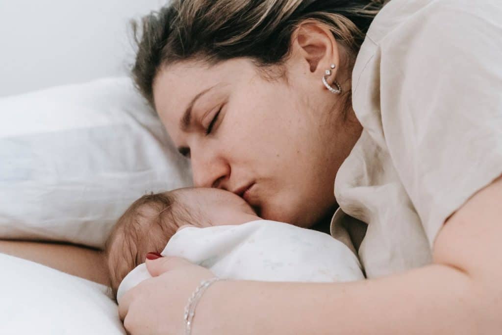 mom kissing baby's forehead