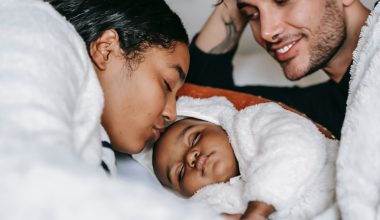mom kissing sleeping baby's forehead