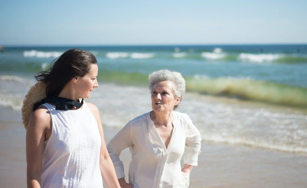 mother and daughter talking on a beach