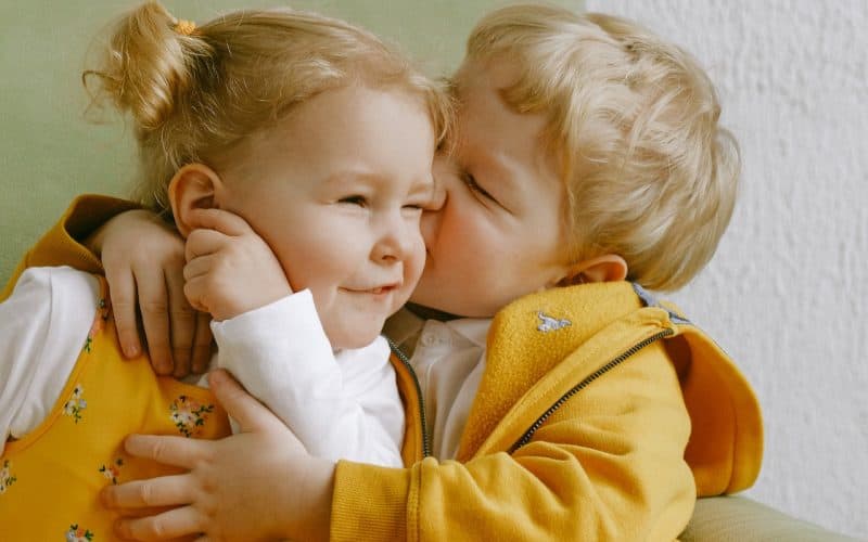 boy kissing his sister