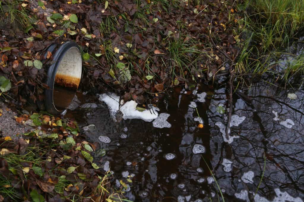 chemicals coming out of a pipe towards a body of water