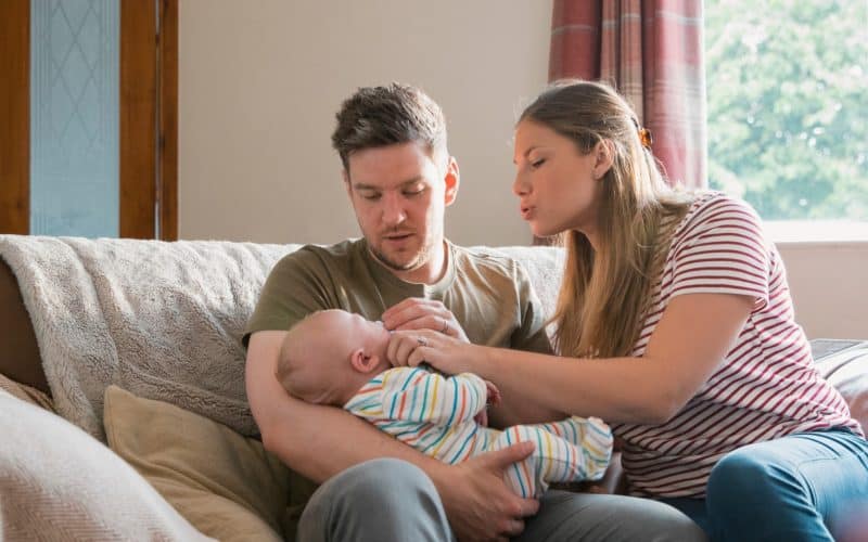 couple sitting on a sofa with baby